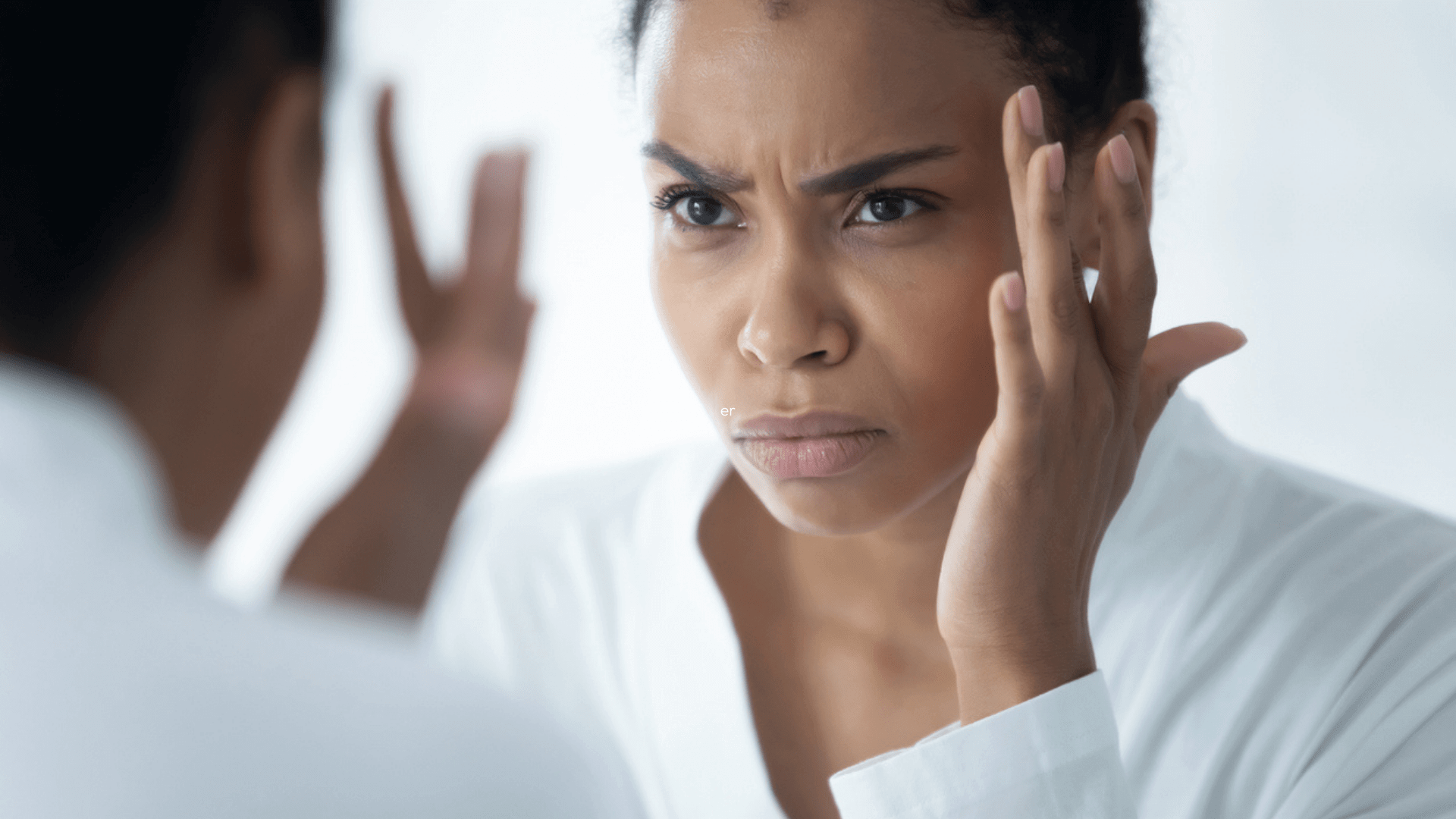 Alt Tag: Botox for Glabellar Lines showing woman examining frown lines between eyebrows in mirror before cosmetic treatment