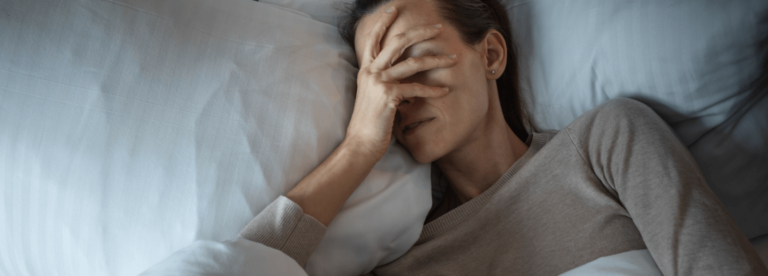 How Much does Botox for Migraines Cost in Oakville? woman lying in bed with severe migraine pain, hand covering face