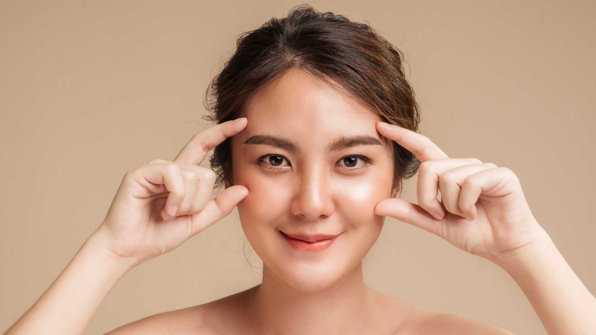 Young woman demonstrating facial exercises for non-invasive Botox alternatives with clear radiant skin