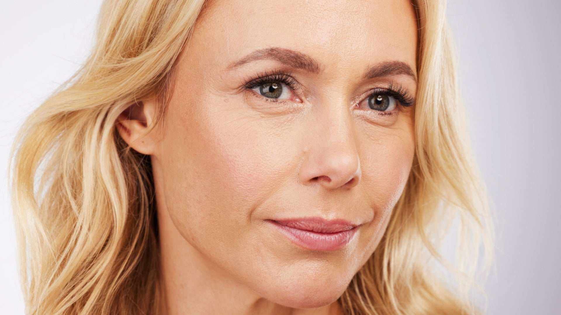 close-up of a middle-aged woman with smooth skin showcasing the effects of injectable dermal fillers on her face