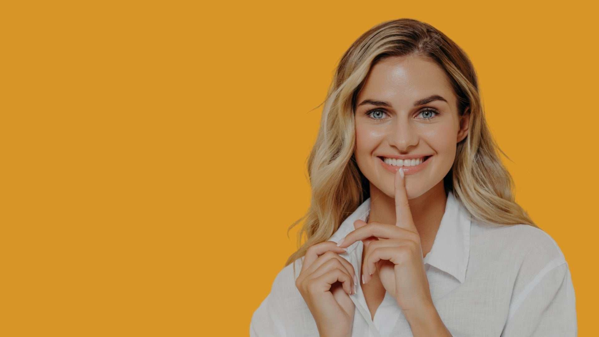 Smiling woman touching her lips representing lip filler clinic services