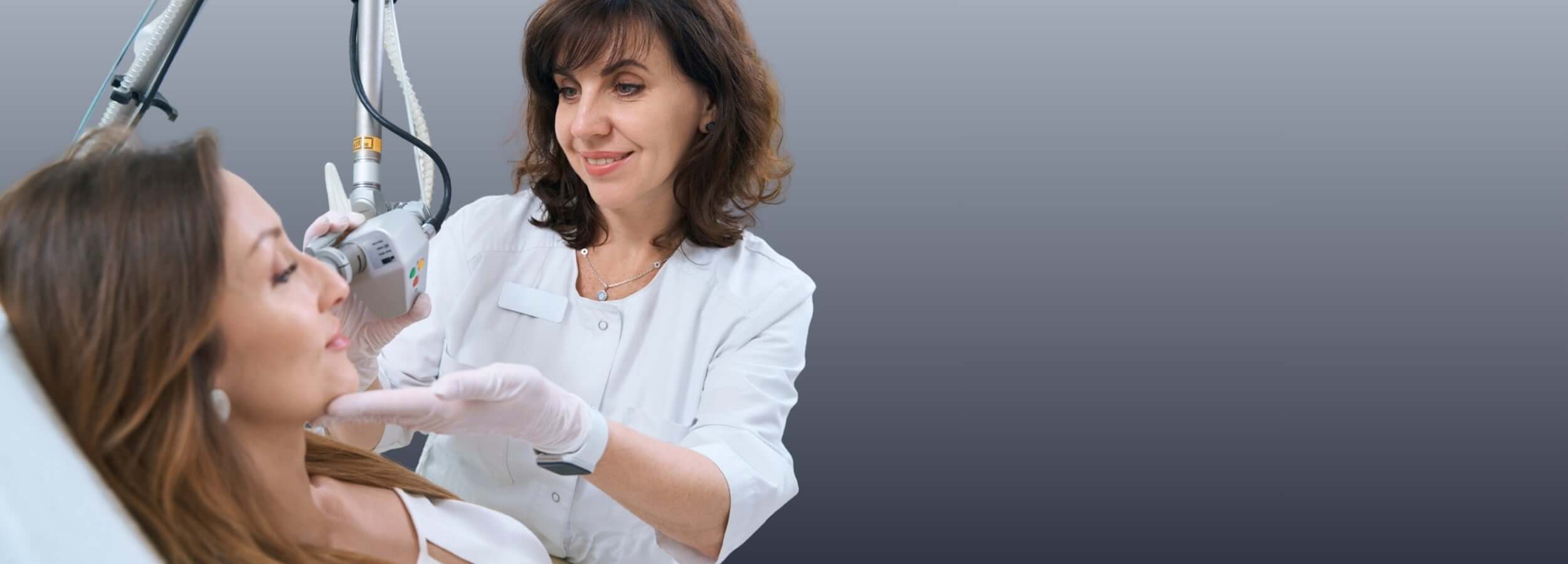 Benefits and Risks of Fraxel Treatment Explained: dermatologist performing Fraxel laser skin resurfacing on patient in clinic