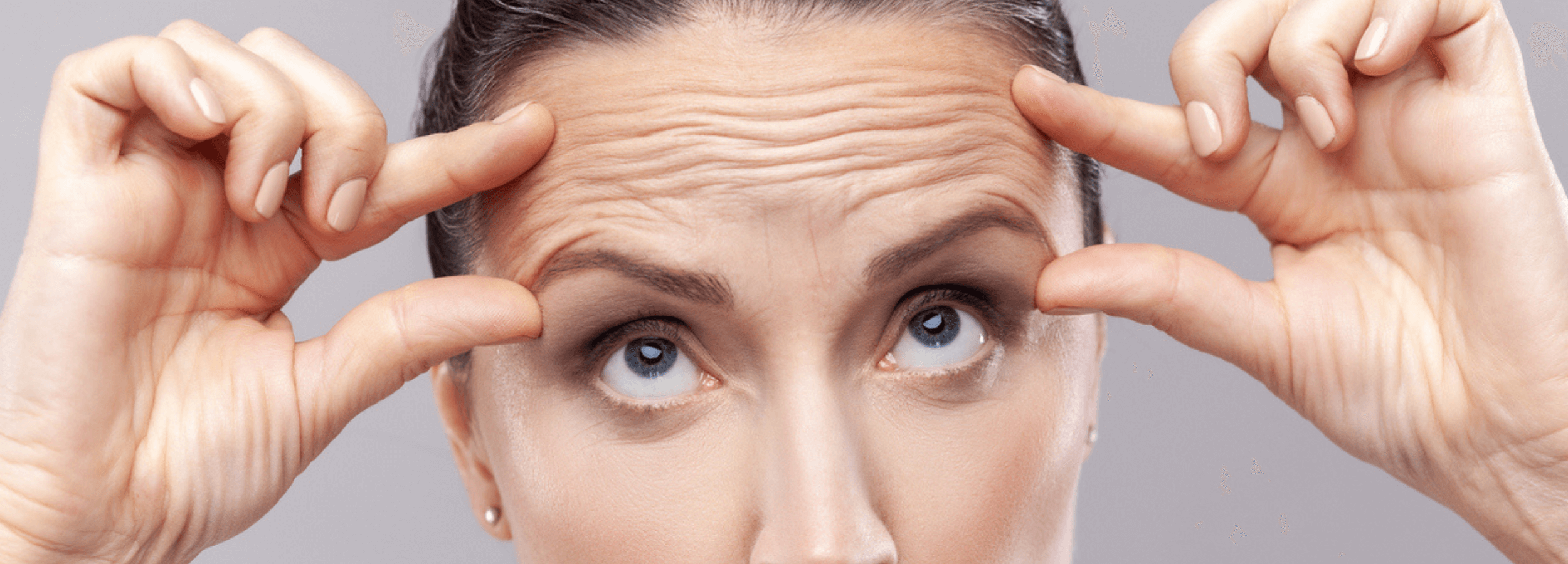 How Many Botox Units for Forehead? woman lifting forehead skin showing wrinkles and expression lines before Botox treatment