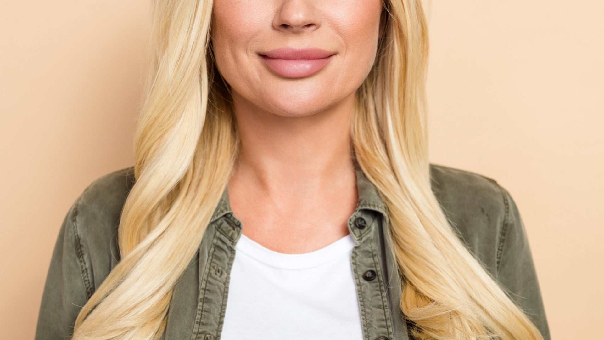 Close-up of a woman with long blonde hair and natural-looking full lips after lip augmentation treatment in Mississauga and Oakville.