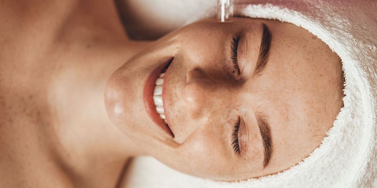 Person receiving a facial treatment with a towel on their head