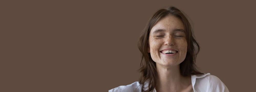 Effective Sun Spot Removal Laser Treatments: smiling woman with visible sun spots on cheeks and nose, skin pigmentation example