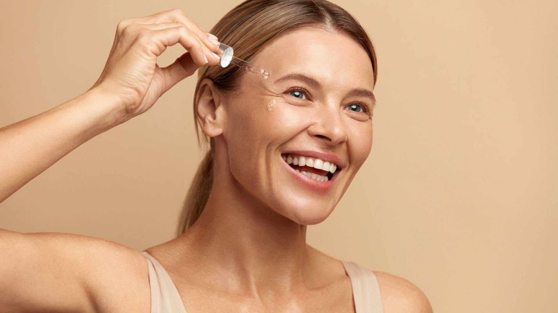 Alt Tag: Unlocking the Benefits of Collagen Serum for Radiant Skin - woman applying collagen face serum with dropper for firm, glowing skin