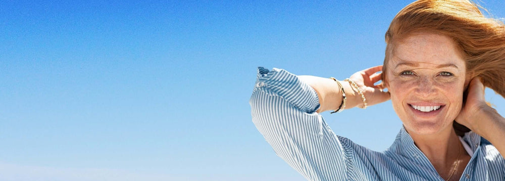 Alt Tag: 5 Myths About Laser Freckle Removal Debunked - smiling woman with freckles outdoors in sunlight, considering laser freckle removal