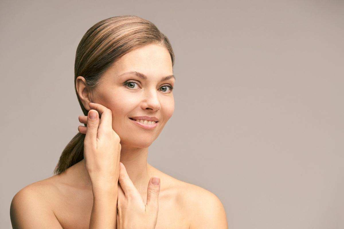Smiling woman touching her face showcasing smooth skin after Botox treatment near me guidance