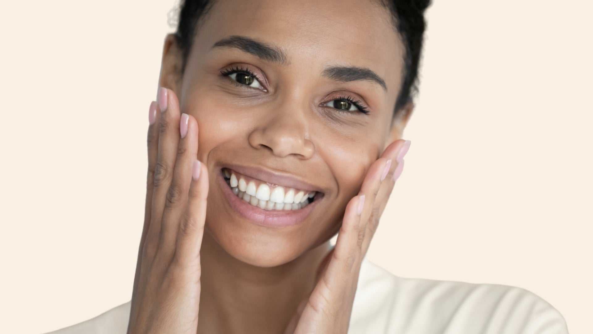 Smiling woman with smooth, clear skin gently touching her face, illustrating transformative effects of Botox treatment.