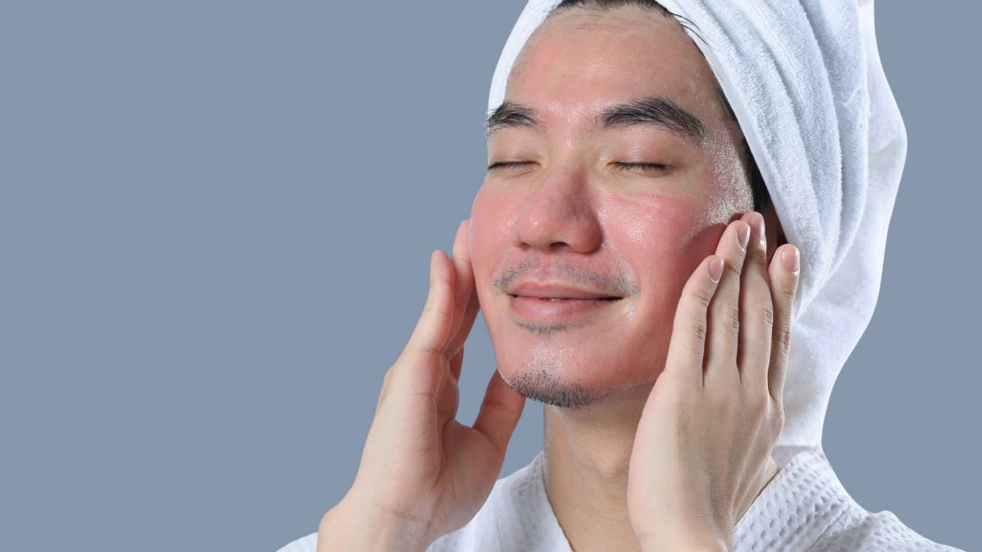 Man with towel on head gently touching his glowing, refreshed face after laser treatment in Toronto