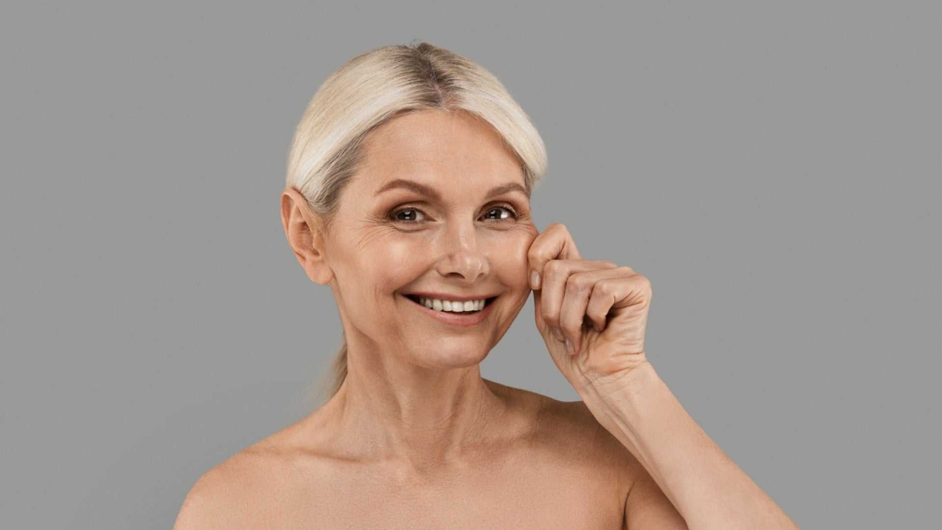 Smiling mature woman demonstrating firm, youthful skin benefits from skin firming laser treatment
