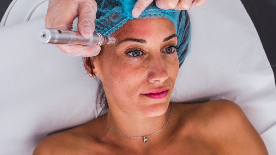 Woman receiving a facial treatment with a professional in a clinical setting.